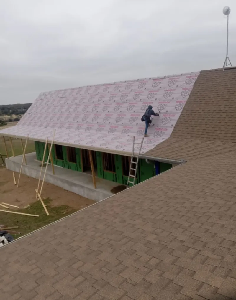 Worker preparing underlayment for a metal roof installation in Ojus